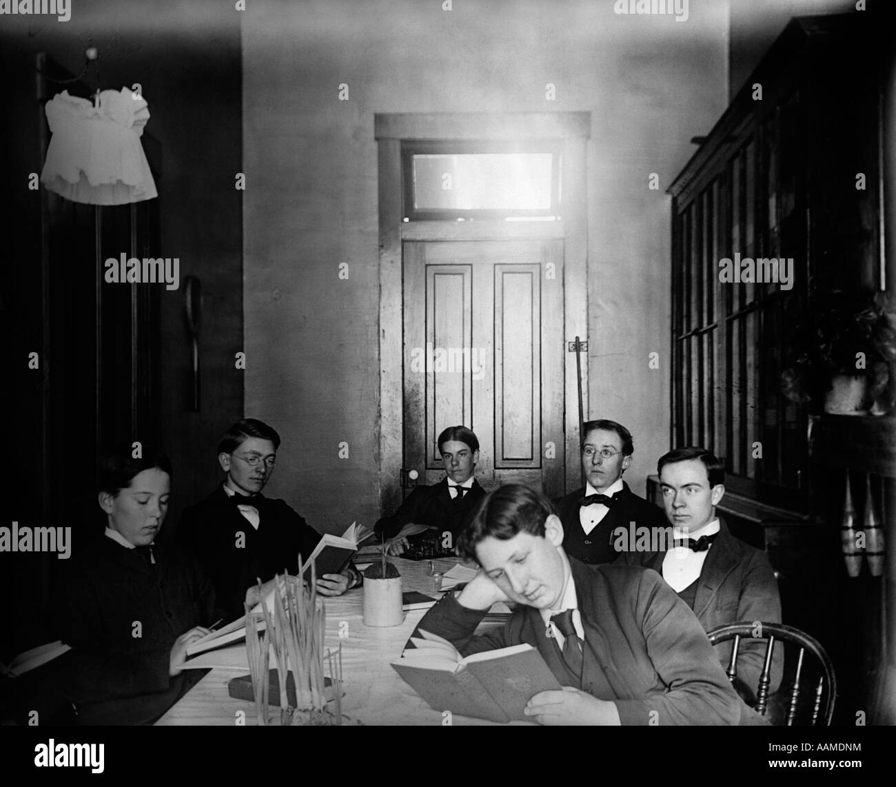 1890s 1900 svolta del secolo gruppo di teen Boarding School boys seduti intorno al grande tavolo studio Foto Stock