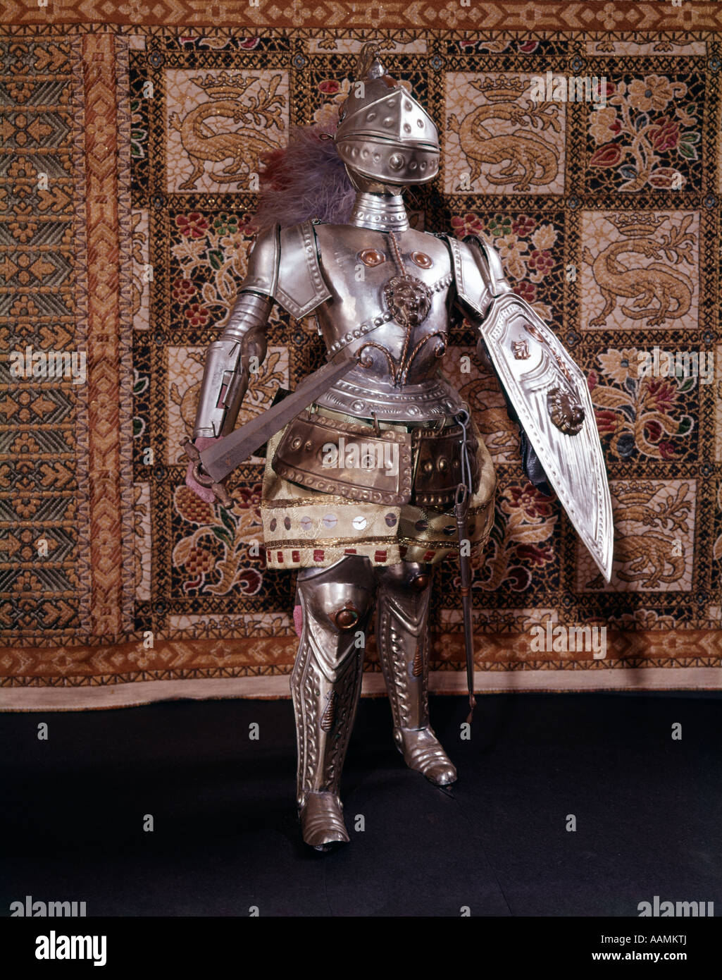 A piena lunghezza completa armatura medievale casco spada scudo metallico di cavalleria del Cavaliere Battaglia guerriero vestito arazzo araldico Foto Stock