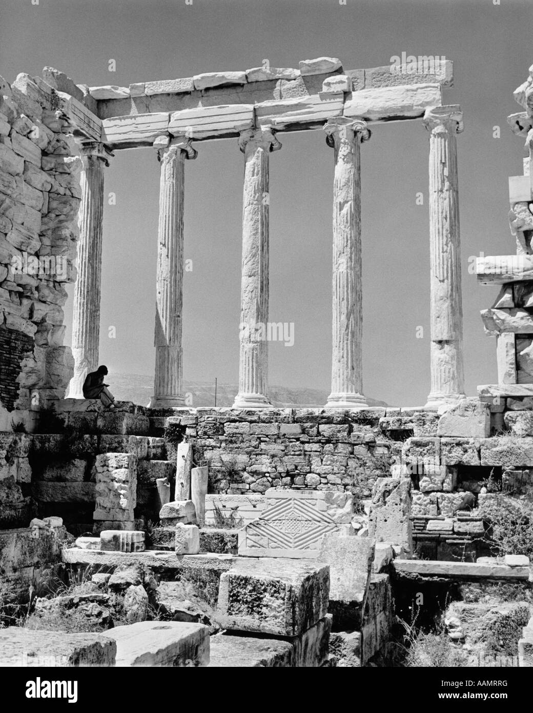 Anni Sessanta colonne greche resti di architettura classica persona turistica libro lettura prima del restauro Partenone Acropoli di Atene Foto Stock