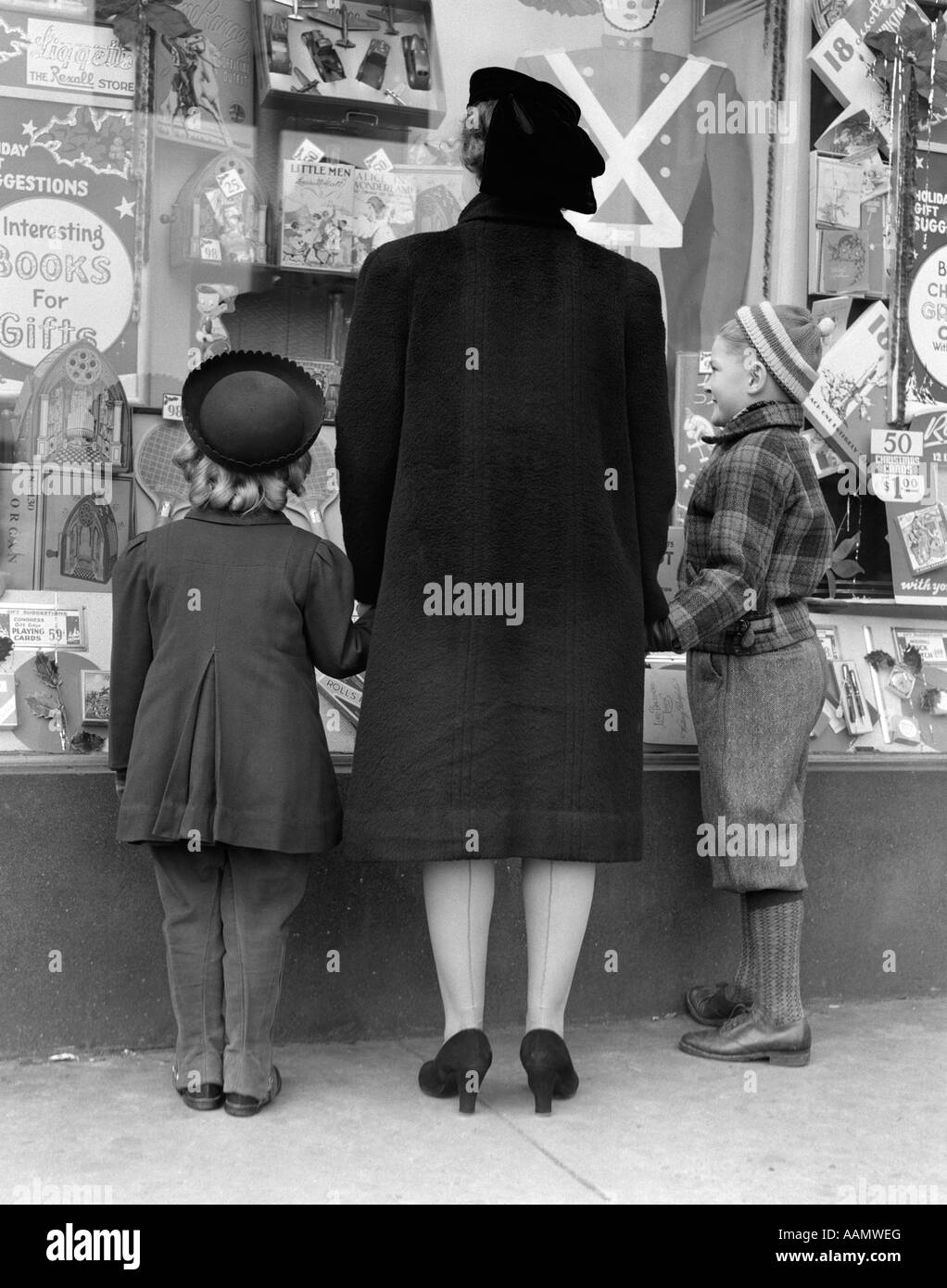 1930s vista di spalle della figlia di madre e figlio di window shopping Foto Stock