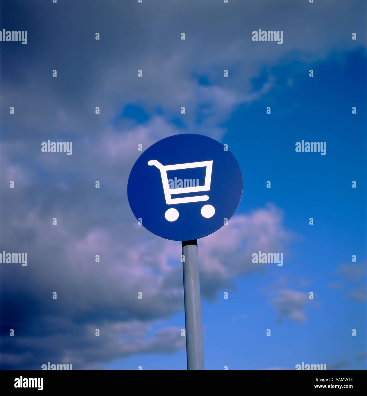 Carrello spesa illustrazione su un disco blu contro un cielo tempestoso in una Co op parcheggio del supermercato, REGNO UNITO Foto Stock