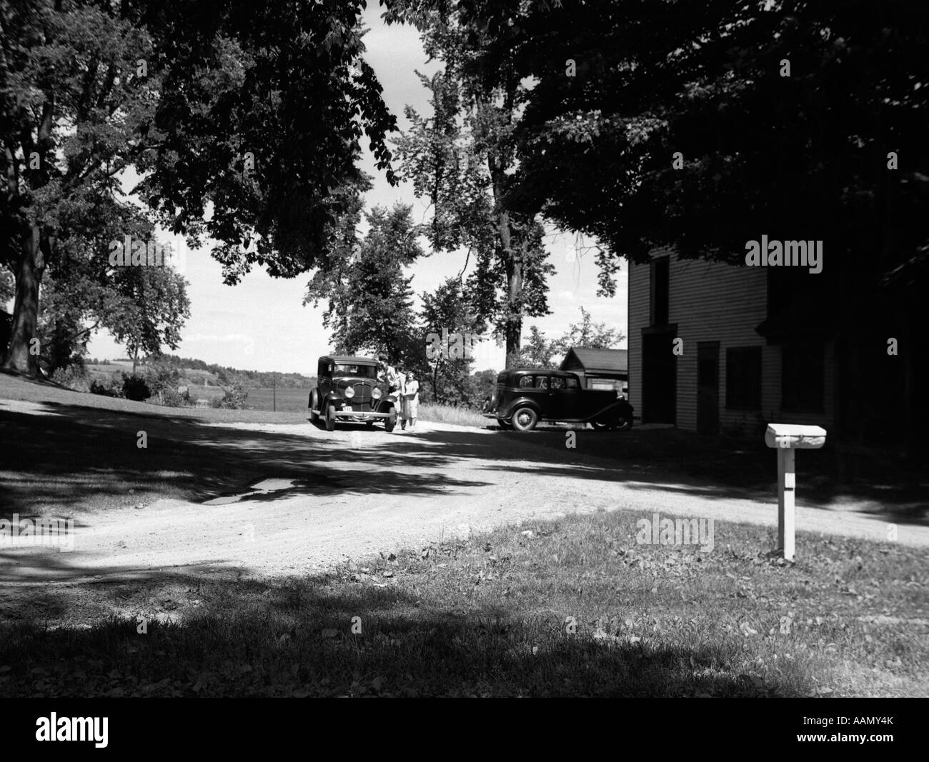 Negli anni Trenta due vetture parcheggiate Casa di paese rurale casella posta a destra e tranquilla città di VEAZIE VICINO A BANGOR MAINE Foto Stock