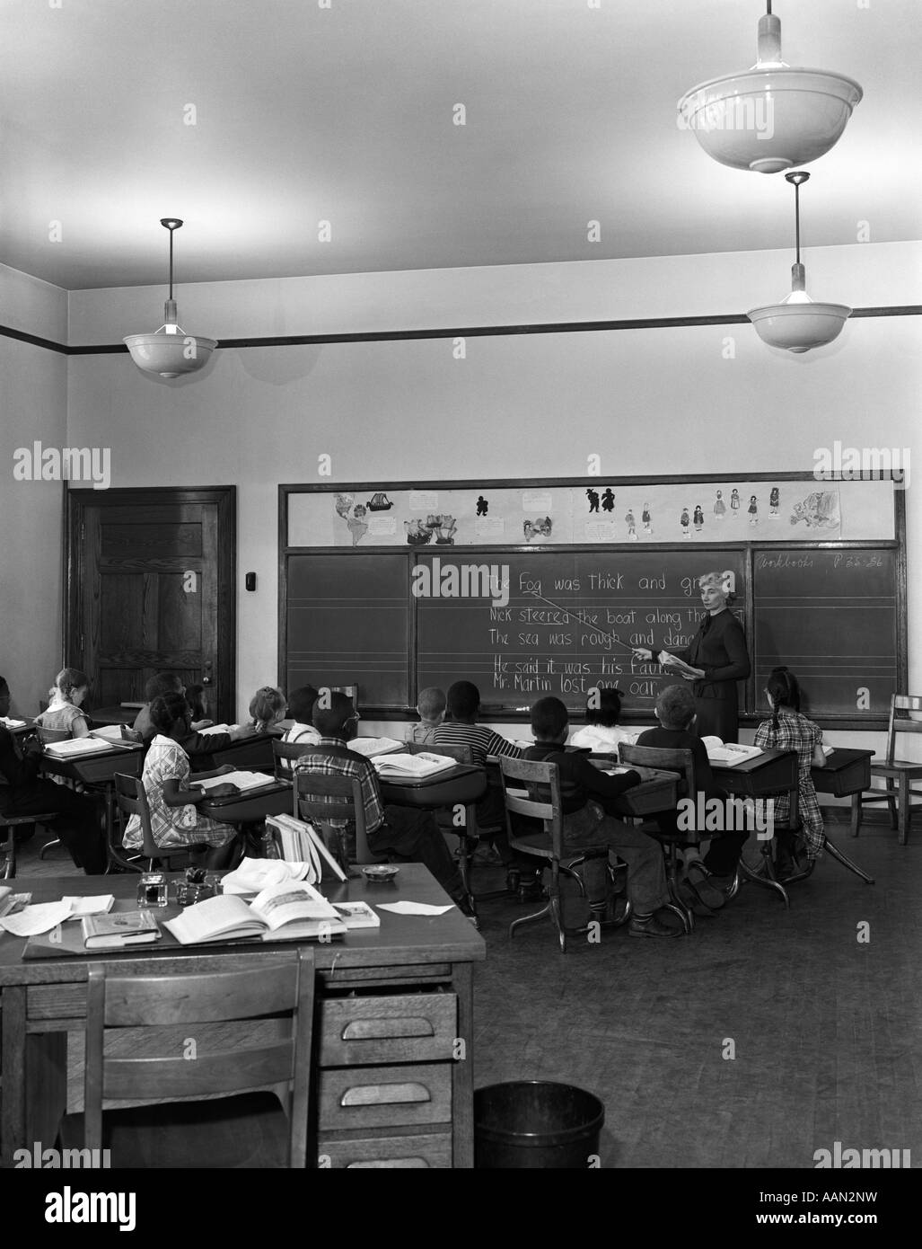 Negli anni quaranta anni cinquanta classe elementare Scuola elementare gli studenti alla scrivania rivolta verso l insegnante Foto Stock