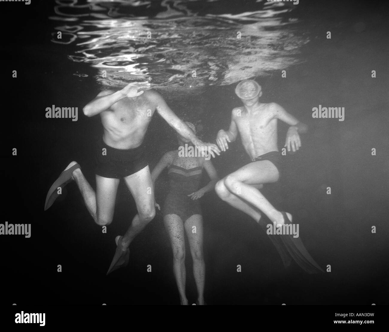 Degli anni Cinquanta vista di tre nuotatori sotto l'acqua Foto Stock