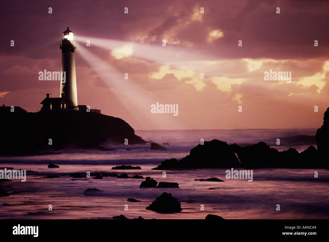Pigeon Point Lighthouse raggio di colata attraverso costa rocciosa e il cielo al tramonto. Immagine non è alterata in modo digitale - Nessun negozio di fotografia. Reale! Foto Stock