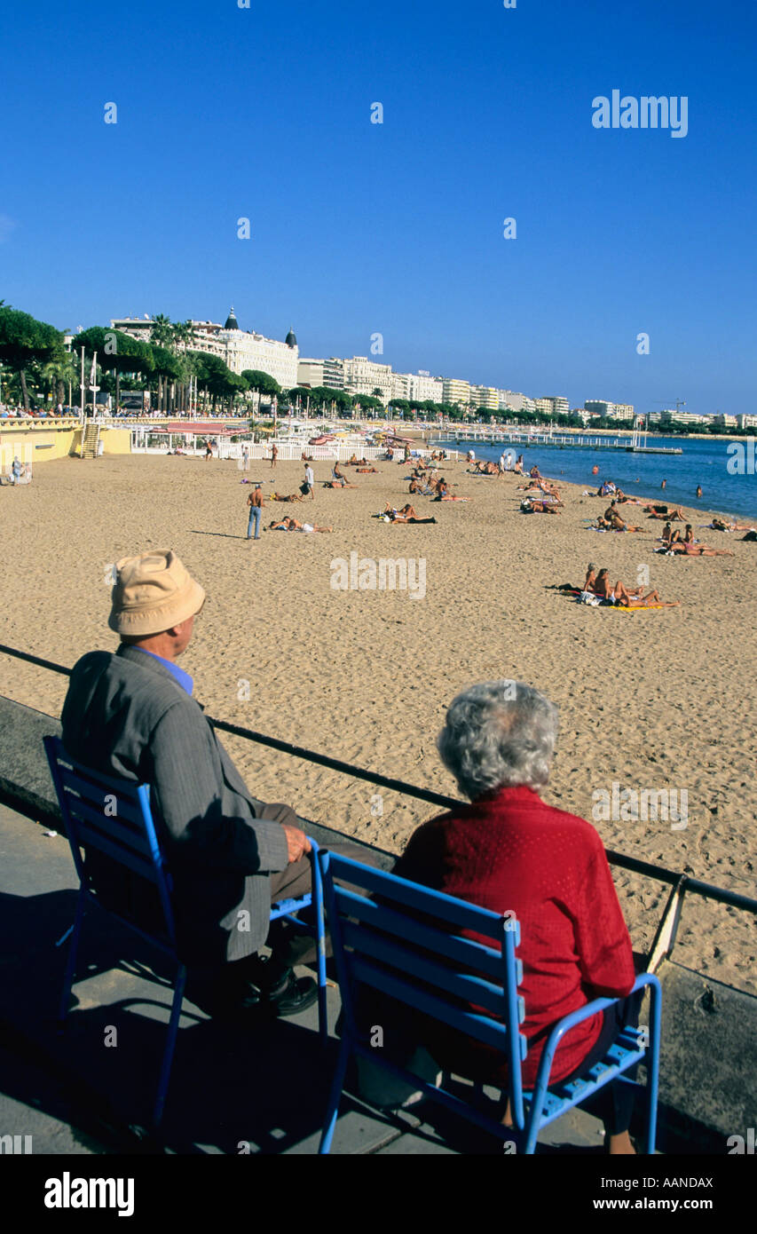 Coppia di anziani seduta che si affaccia sulla spiaggia di Cannes Riviera francese, nel sud della Francia Foto Stock