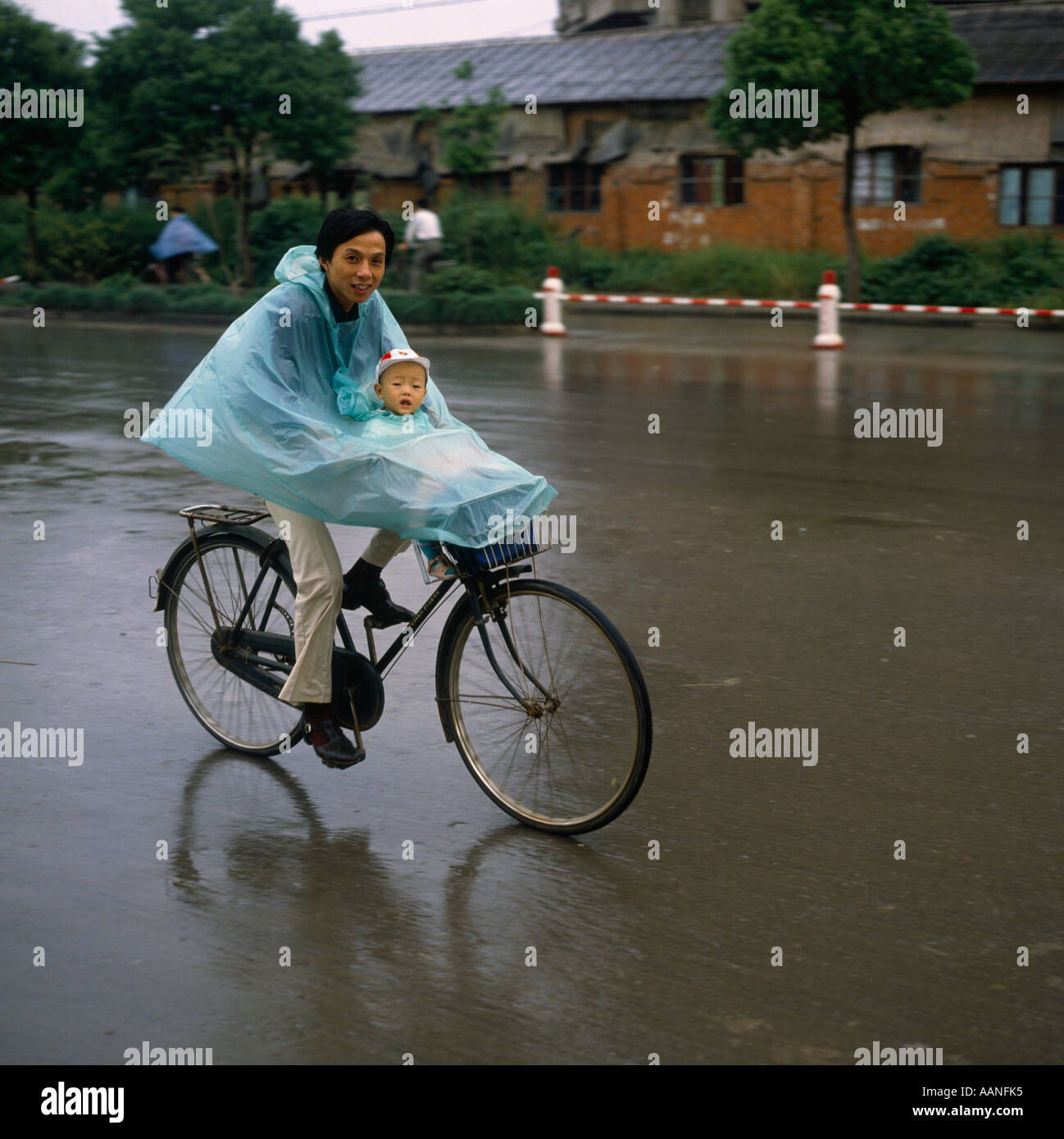 Centimeter I wear clothes Belong Padre e figlio in bicicletta Ciclismo su strada principale sotto la pioggia  che indossa il poncho impermeabili cape a Suzhou Jiangsu Province Cina Foto  stock - Alamy