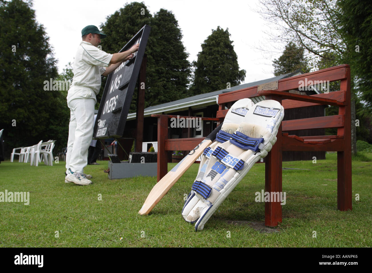 Giocatore di cricket tenere il punteggio al villaggio partita di cricket Foto Stock