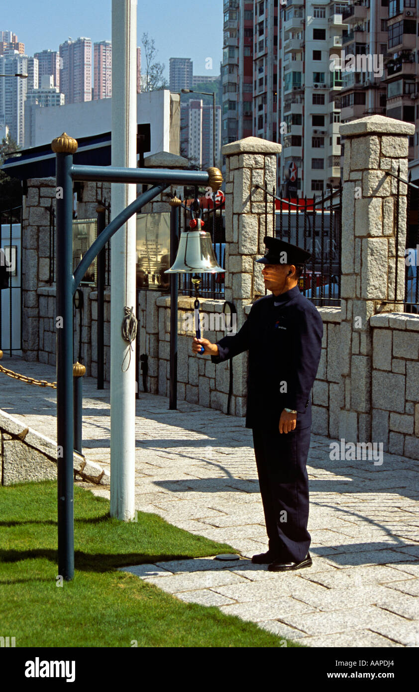 Ufficiali in uniforme e a mezzogiorno Day Gun Bell, la Causeway Bay di Hong Kong, Cina Foto Stock