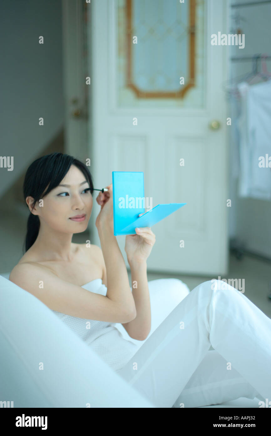 Una giovane donna applicazione di mascara Foto Stock