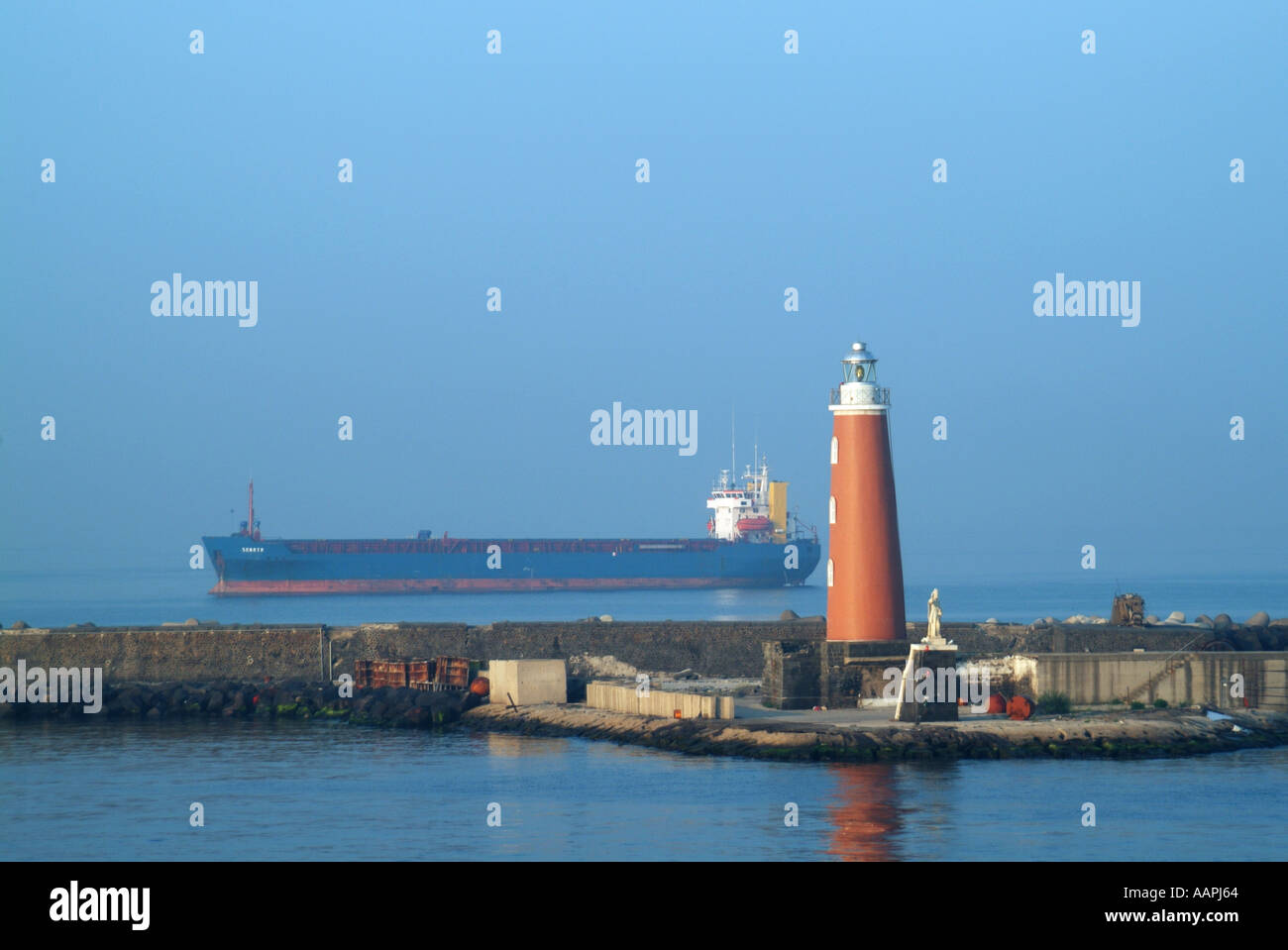 Porto di Napoli nave da carico con parete di Porto Faro di ingresso Foto Stock