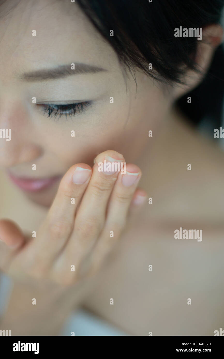 Close-up di una giovane donna messa idratante viso Foto Stock