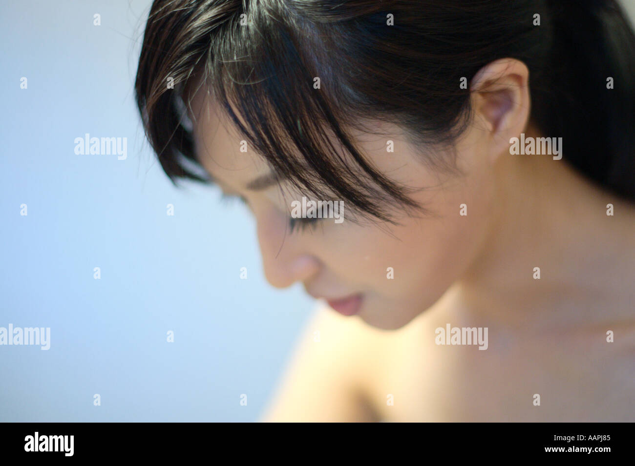 Close-up di una giovane donna che guarda in basso Foto Stock