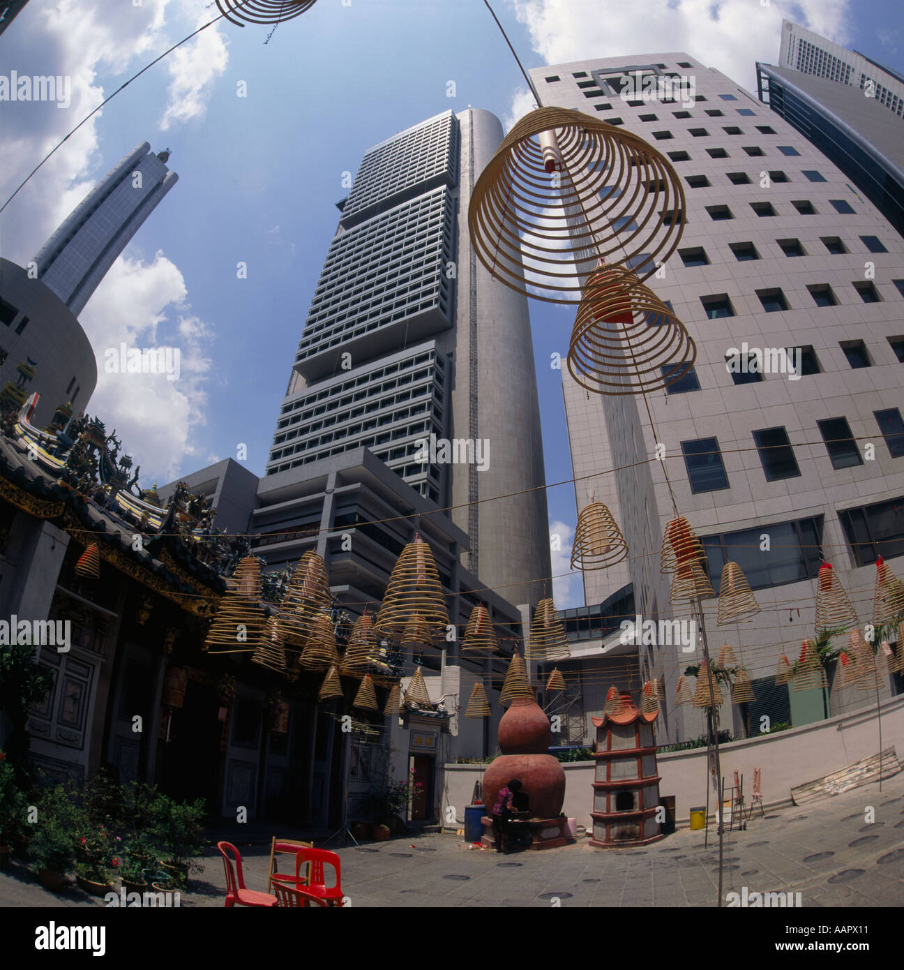 Wak Hai Cheng Bio il tempio Cinese con bobine di incenso appeso il quartiere finanziario in background con obiettivo fisheye Singapore Foto Stock