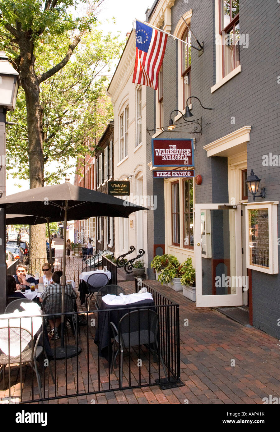 Persone di mangiare al tavolo esterno sulla via della Città Vecchia di Alexandria in Virginia, Stati Uniti d'America Foto Stock