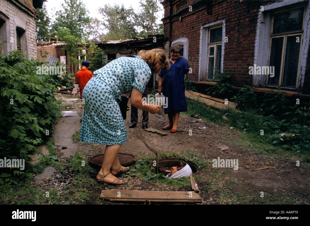 SVERDLOVSK GIUGNO 1991 lavoratore con la sigaretta in una fossa nel giardino sul retro rammendo tubi di burst Foto Stock