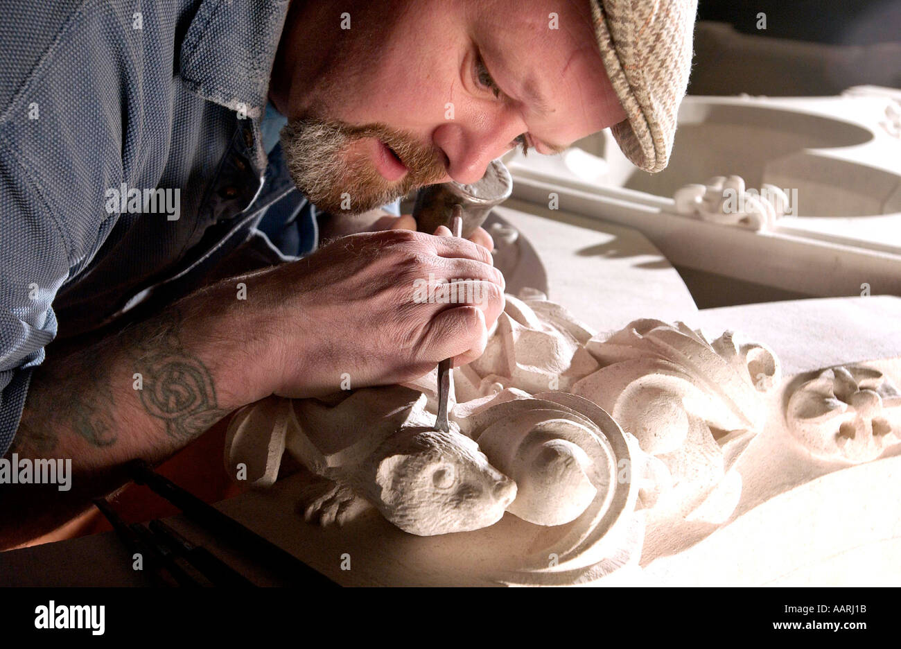 Stone carver Paolo Ellis lavora sull'effige di un furetto a Cattedrale di Lincoln Foto Stock