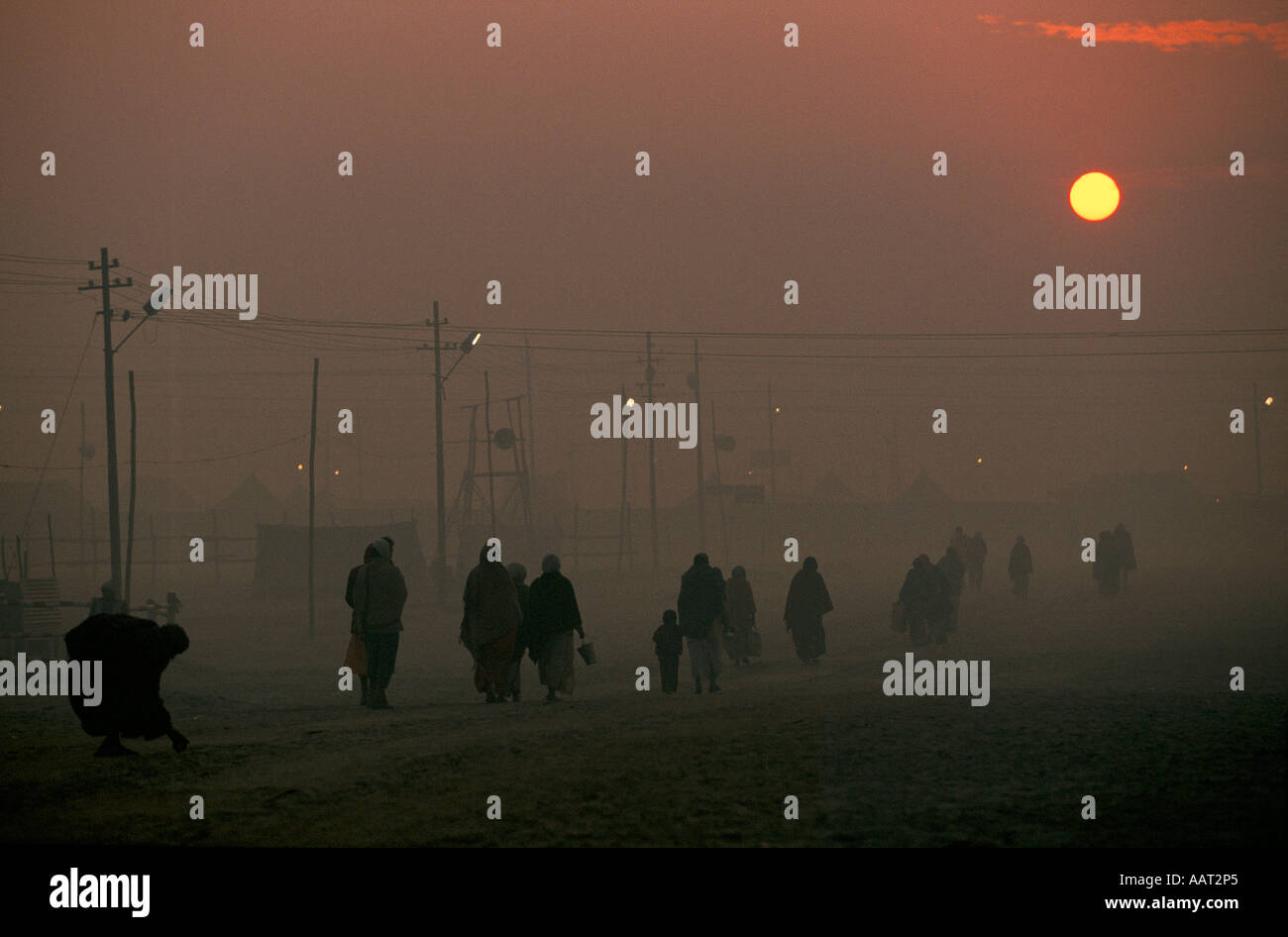 KUMBH MELA INDIA 2001 come il sole tramonta il fumo di fuochi di legno rende una spessa smog pellegrini tornare nei loro campi 2001 Foto Stock