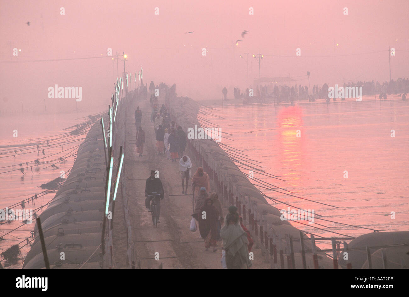KUMBH MELA INDIA 2001 come il sole tramonta pellegrini fanno la loro strada attraverso i ponti temporanei nei loro campi 2001 Foto Stock