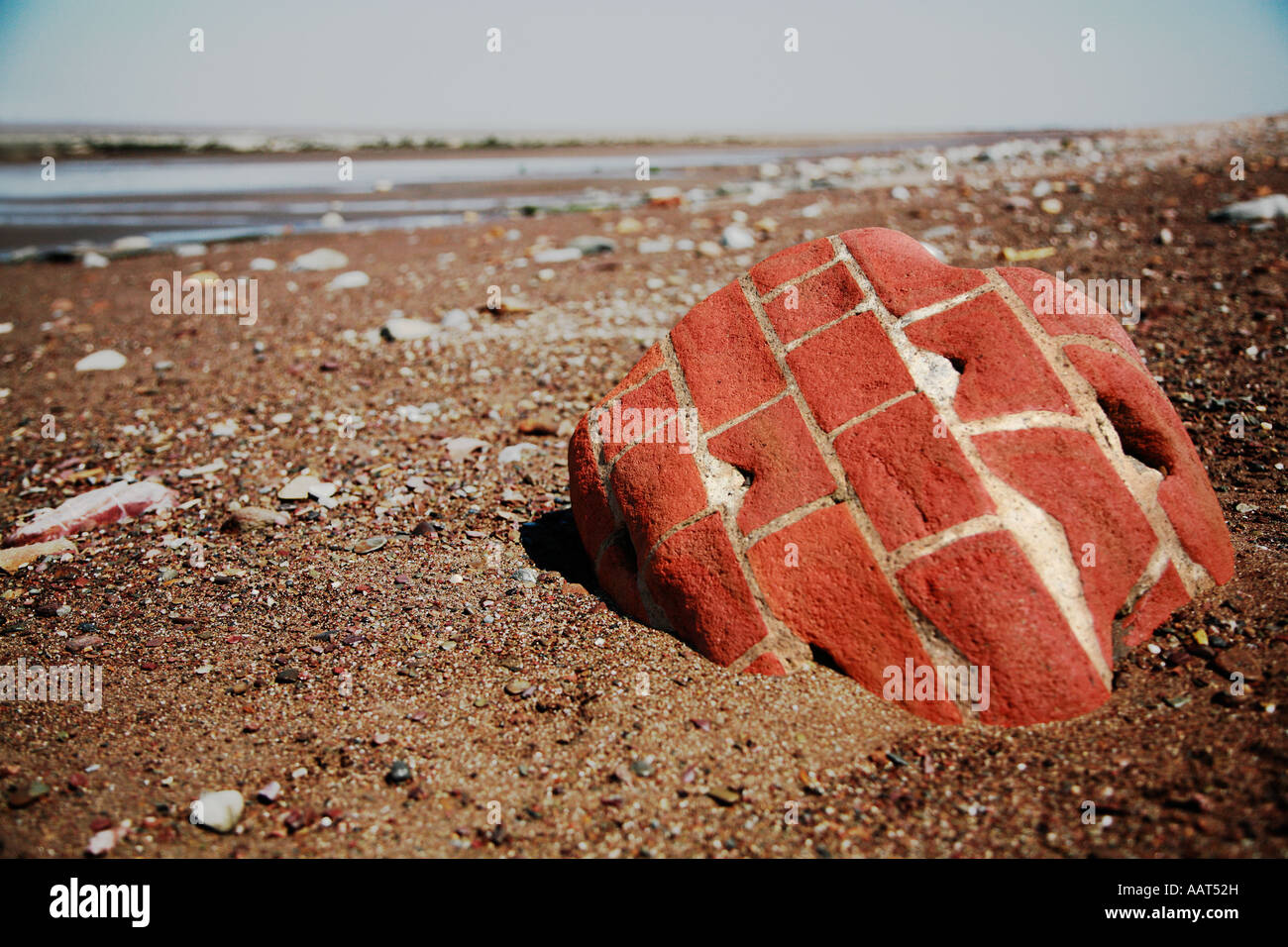 Alterò la sezione di un muro di mattoni levigato e arrotondato dal mare Foto Stock