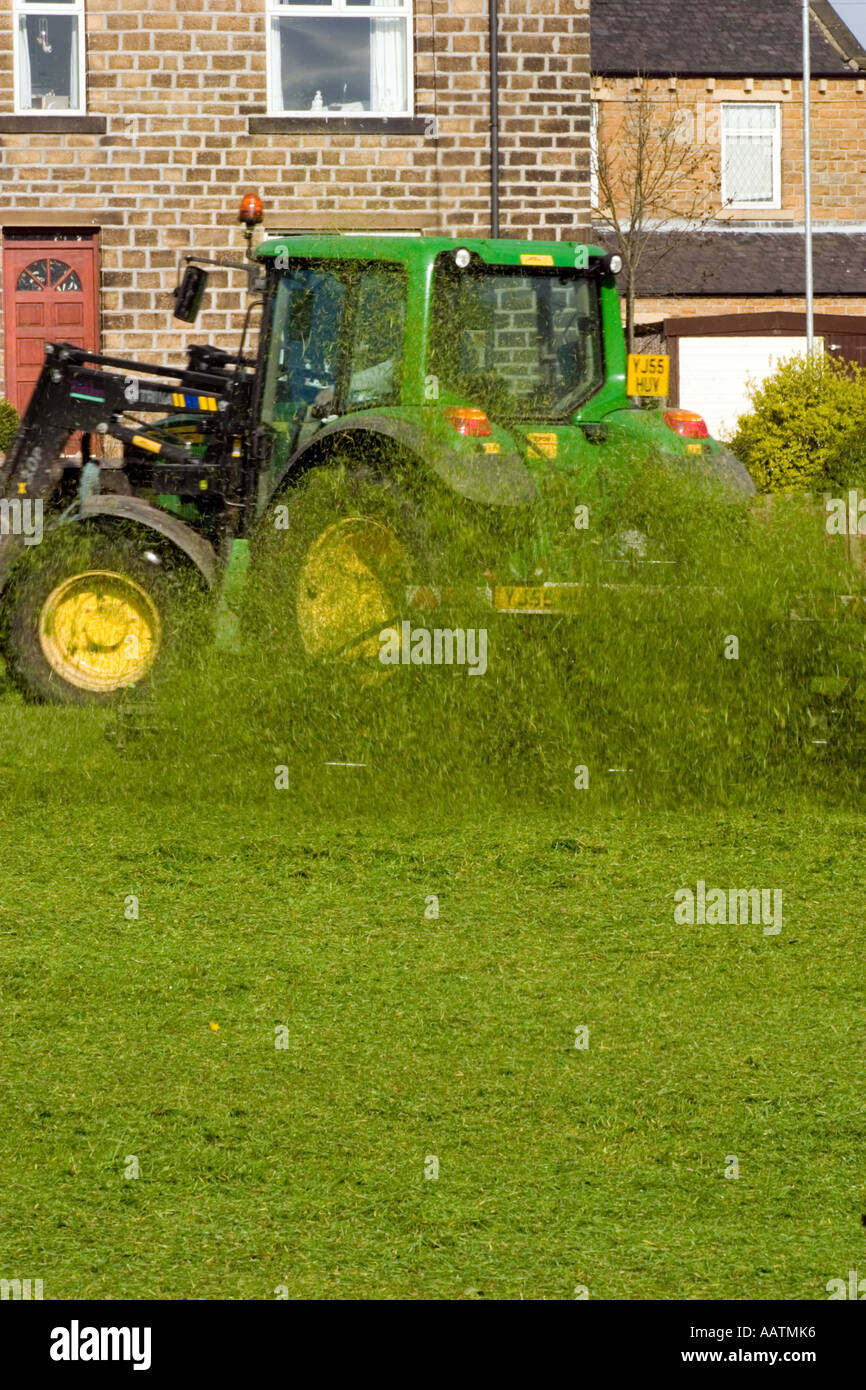 Pista falciatrice tirata dal trattore il taglio di erba sulla riproduzione comunale campo libero lo spazio per testo Foto Stock