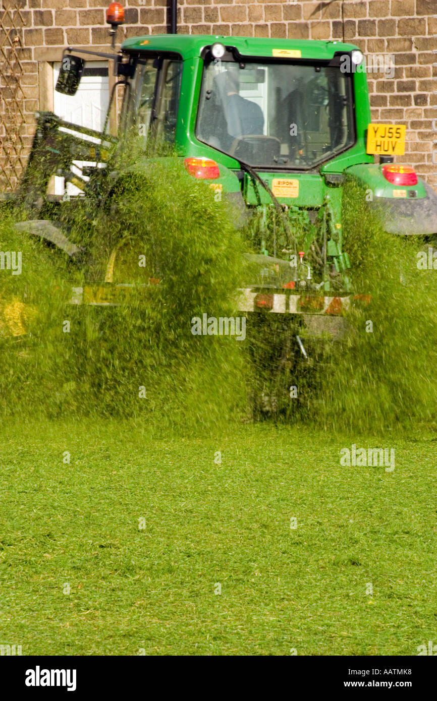 Pista falciatrice tirata dal trattore il taglio di erba sulla riproduzione comunale campo libero lo spazio per testo Foto Stock