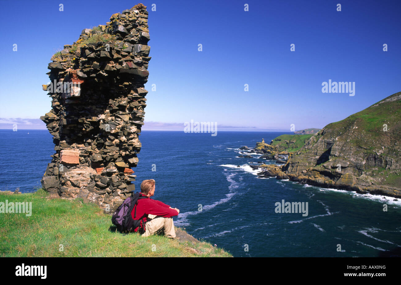 Passeggiate costiere walker a resti del castello di veloce guardando al mare e stack St Abbs Head Berwickshire litorale Scotland Regno Unito Foto Stock