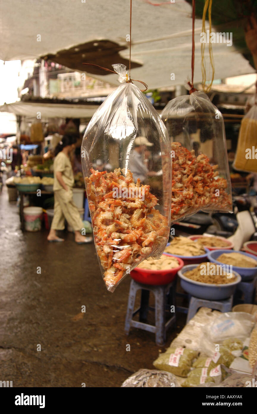 Gamberi secchi appesi in sacchetti di plastica in un mercato vietnamita Foto Stock