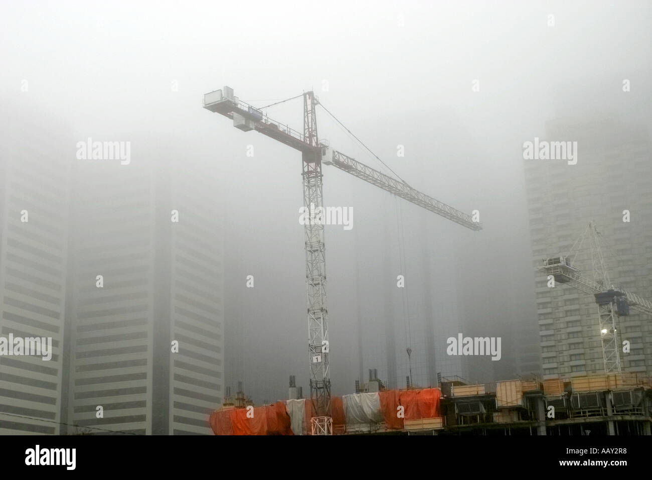 Nebbioso giorno; gru da cantiere nel centro cittadino Foto Stock