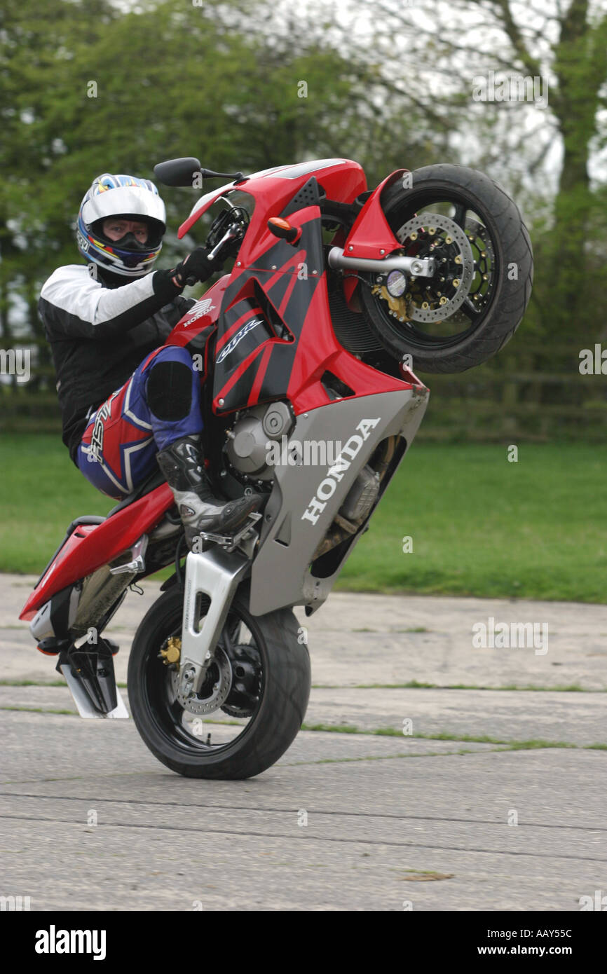 Uno stuntman tira una impennata su una Honda CBR600RR moto Foto Stock