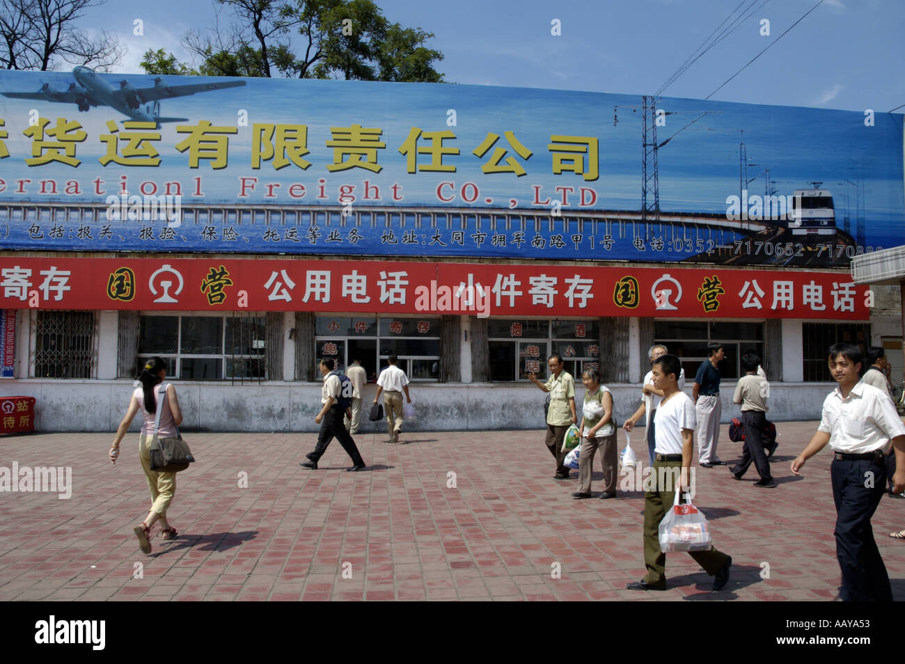 La gente camminare passato le vendite di biglietti della finestra in una stazione ferroviaria di Datong, Shanxi, Cina. Foto Stock