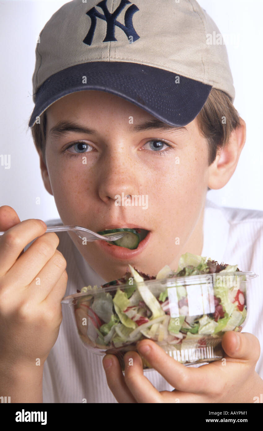 Ragazzo adolescente insalata mangiare Foto Stock