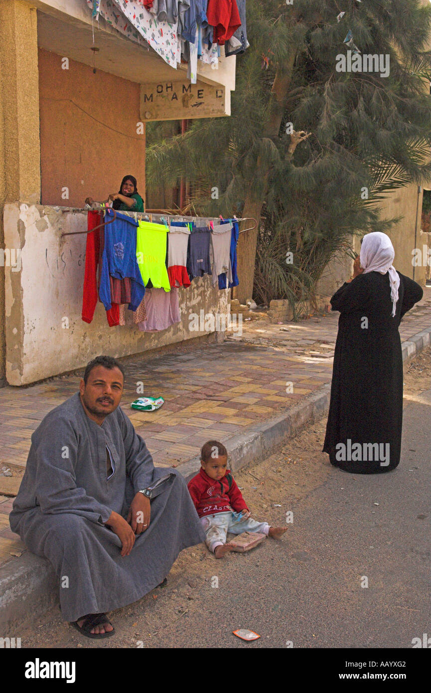 Egyptian uomo seduto sul marciapiede con un giovane bambino accanto a lui città vecchia ed Dahar regione Hurghada Egitto Foto Stock