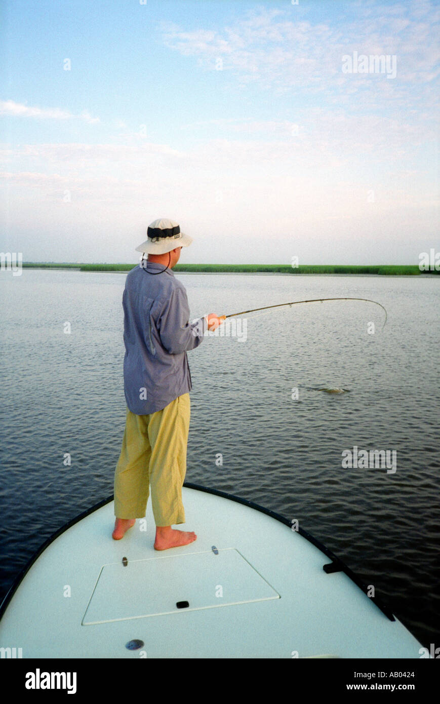 Uomo di Pesca a Mosca Report di Pesca fuori prua della barca a Savannah in Georgia USA Modello e Proprietà immagine rilasciata Foto Stock