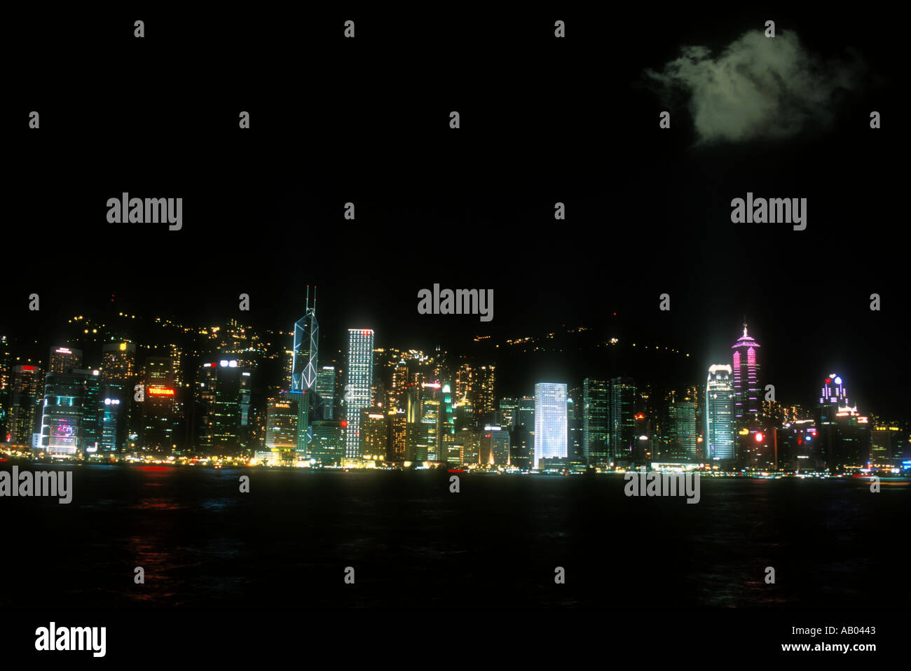Skyline di Hong Kong viste attraverso il porto di notte Hong Kong Cina Foto Stock