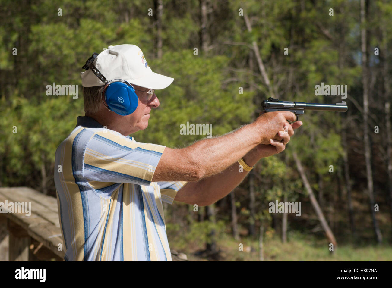 Voce maschile senior citizen mira pistola pistola durante il tiro al bersaglio al poligono di tiro in Ocala National Forest Ocala, Florida USA Foto Stock
