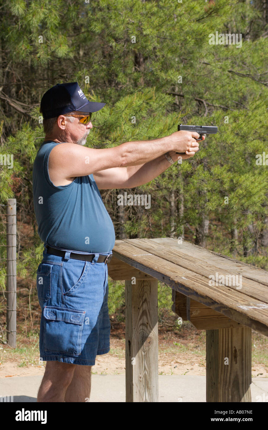 Uomo mira pistola durante il tiro al bersaglio al poligono di tiro in Ocala National Forest Ocala, Florida USA Foto Stock