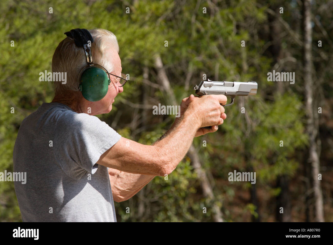 Voce maschile senior citizen mira pistola pistola durante il tiro al bersaglio al poligono di tiro in Ocala National Forest Ocala, Florida USA Foto Stock