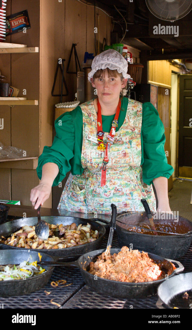 Dipendente vestito in costumi periodo cuochi cucina casalinga in skillets a Dollywood theme park in Pigeon Forge, Tennessee, Stati Uniti d'America Foto Stock