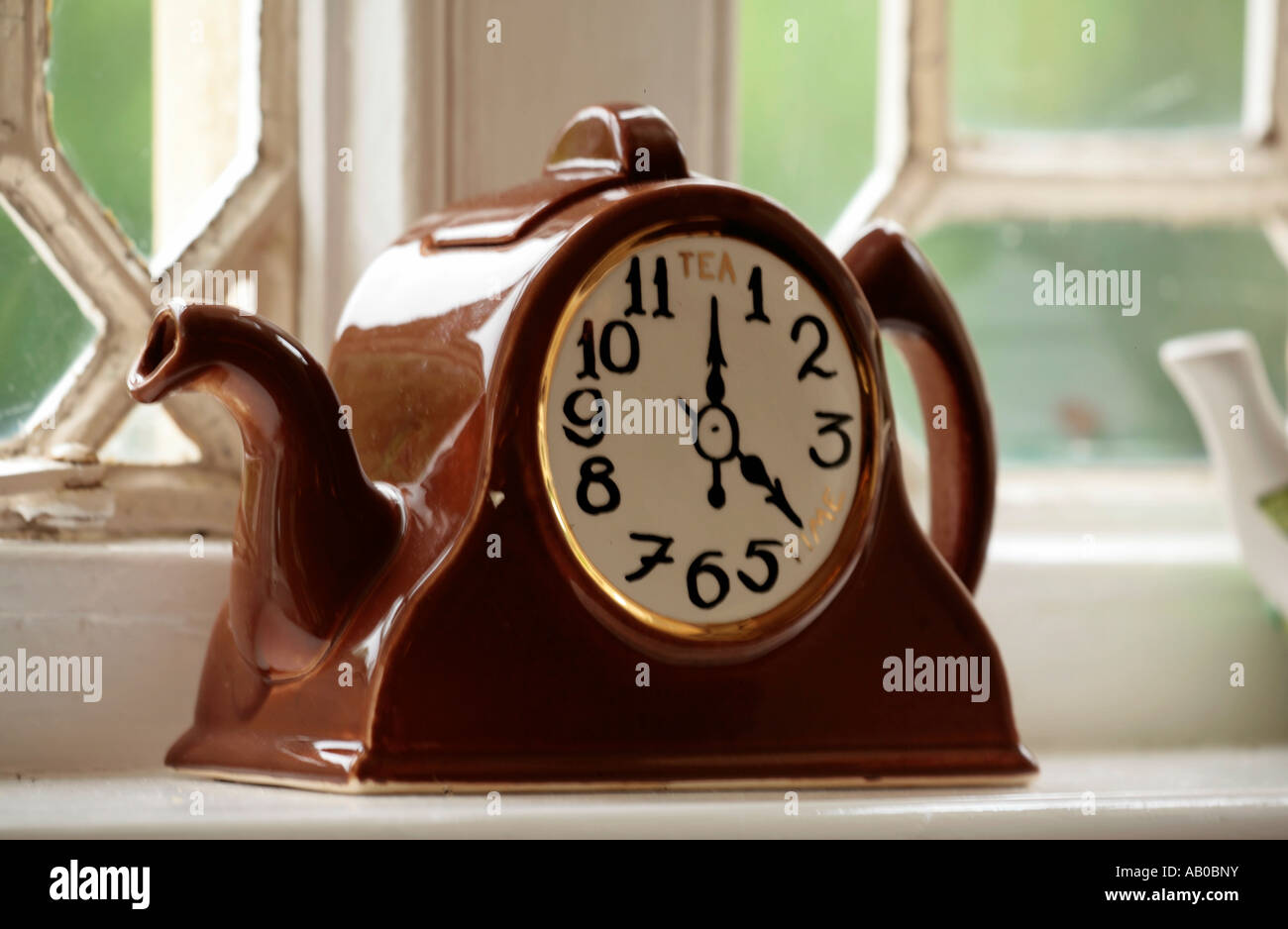 Novità teiera a forma di orologio, seduto sul davanzale Foto Stock