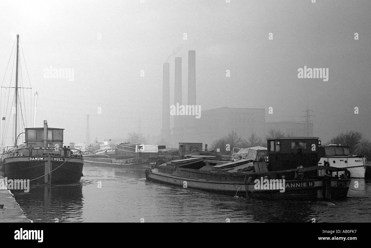 Barge In viaggio lungo Canal in inverno con Coal Fired power station in background. Foto Stock