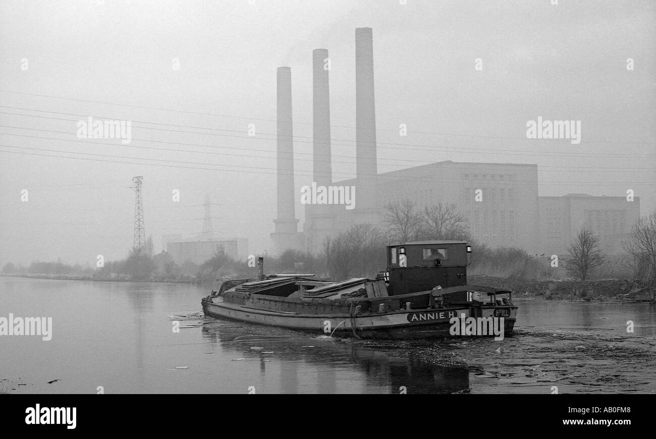 Barge In viaggio lungo Canal in inverno con Coal Fired power station in background. Foto Stock