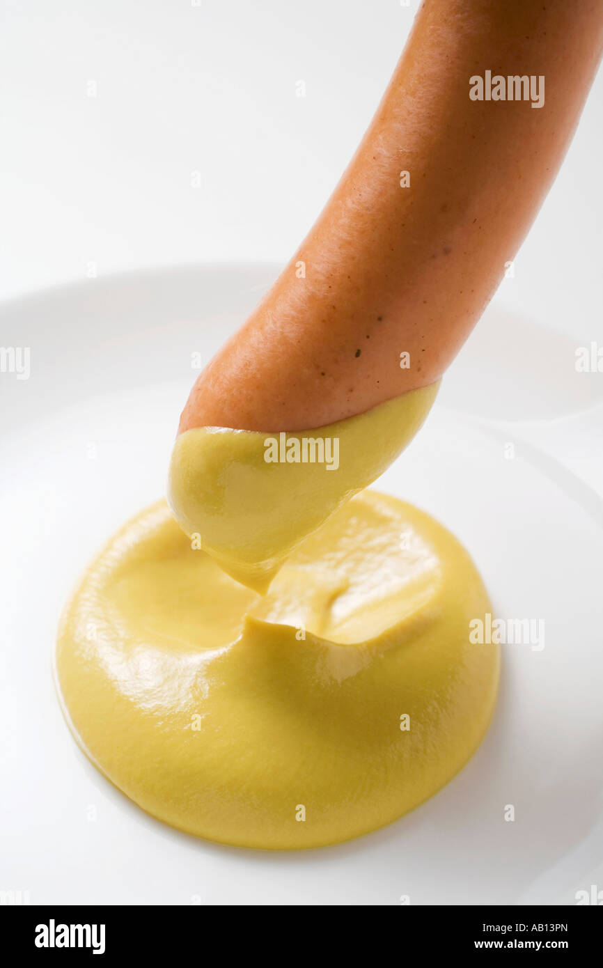 Immergere una salsiccia in FoodCollection senape Foto Stock