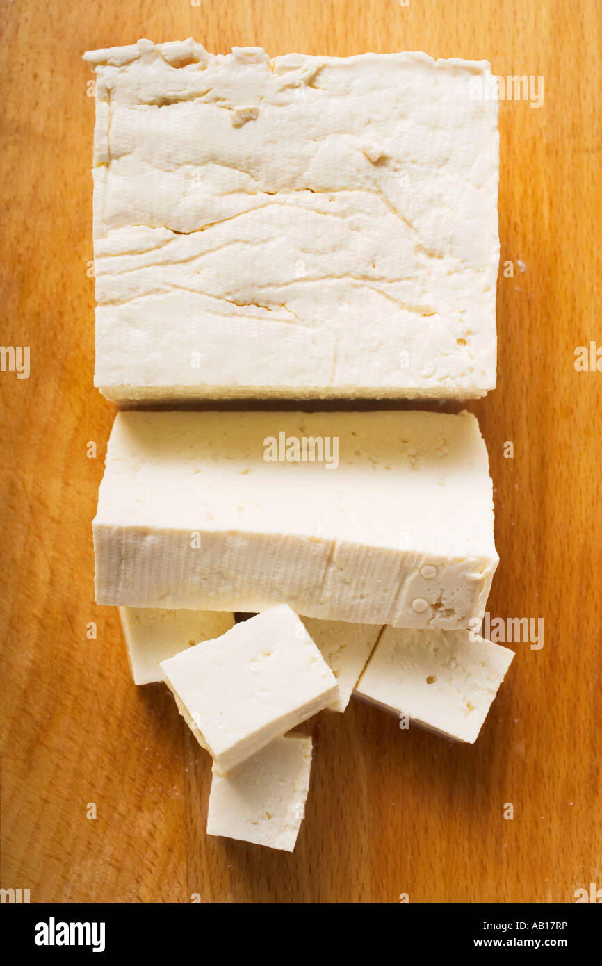 Il tofu un blocco una fetta e tagliata a dadini su sfondo di legno FoodCollection Foto Stock