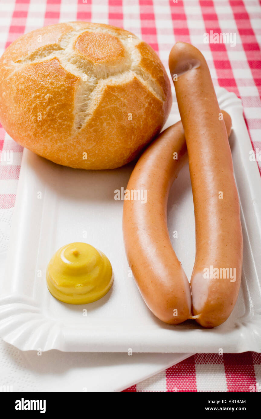 Wurstel con senape e pane rotolo sul piatto di carta FoodCollection Foto Stock