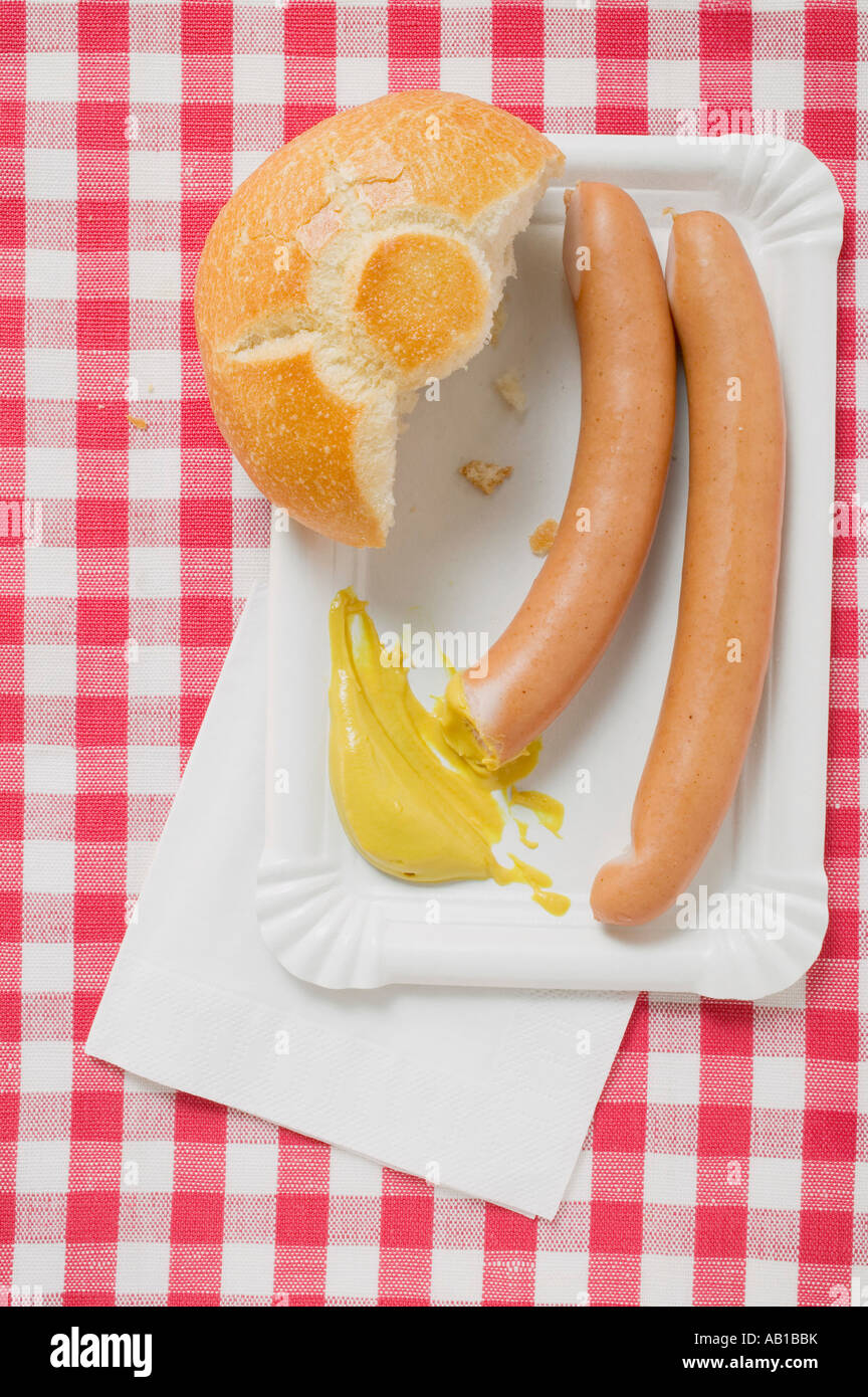Wurstel con senape e pane rotolo sul piatto di carta FoodCollection Foto Stock