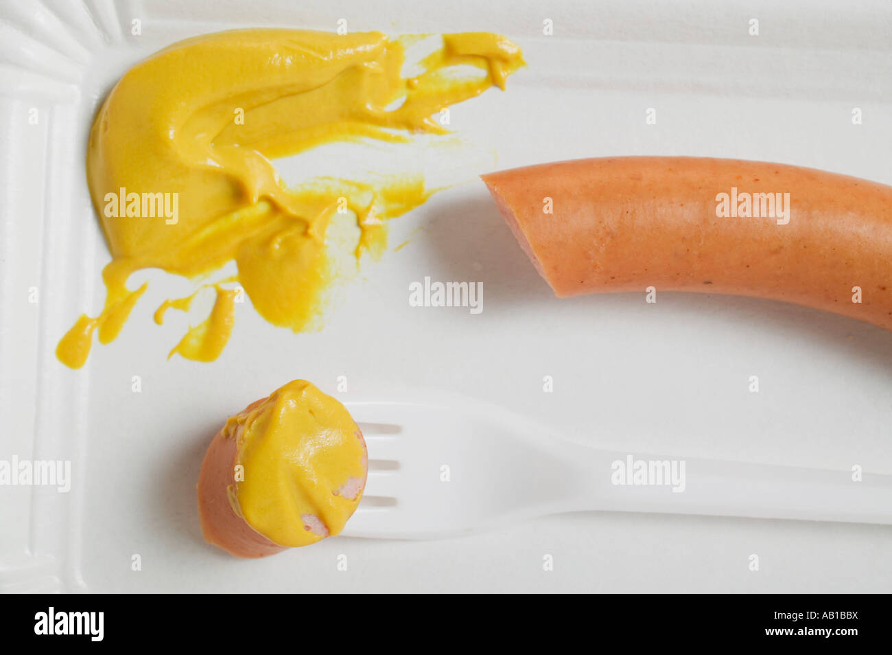 Frankfurter con senape sul piatto di carta FoodCollection Foto Stock