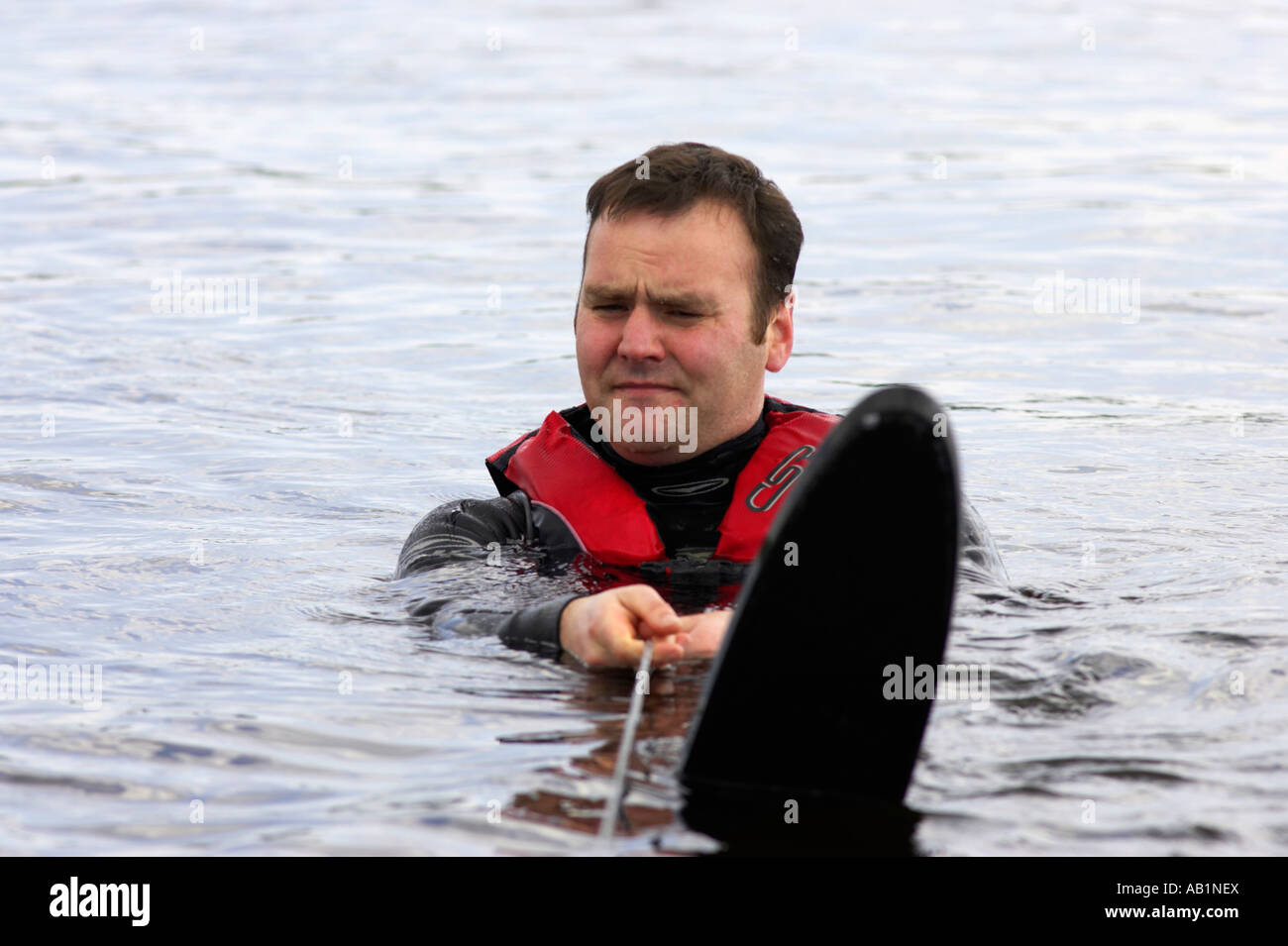 In prossimità di metà 30s waterskier galleggiante in acqua appesa alla fune di traino che indossa lo sci d'acqua in attesa di essere trainato Foto Stock