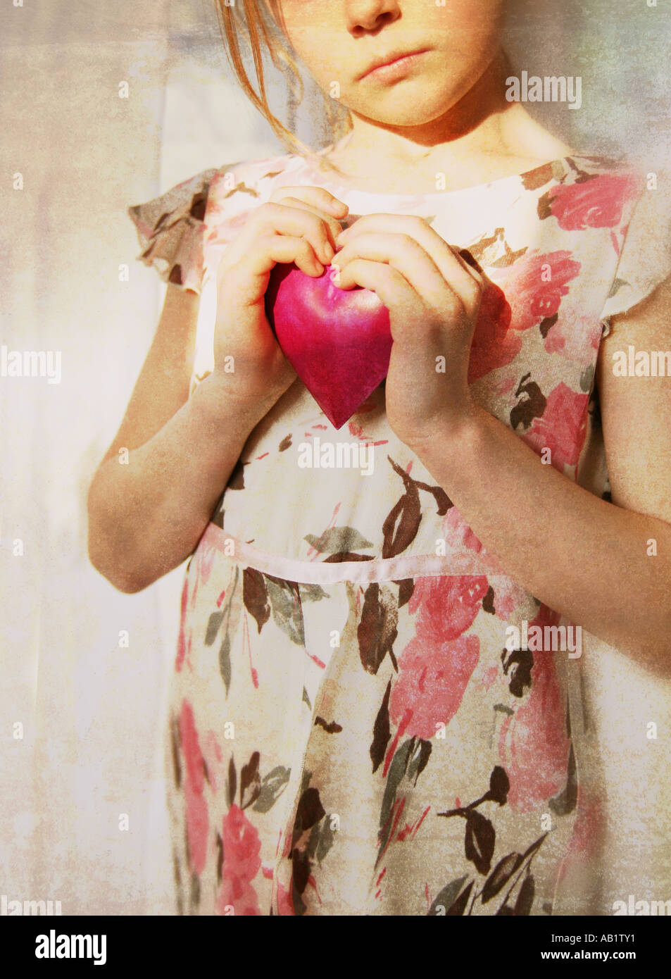 Una ragazza con un cuore rosa Foto Stock