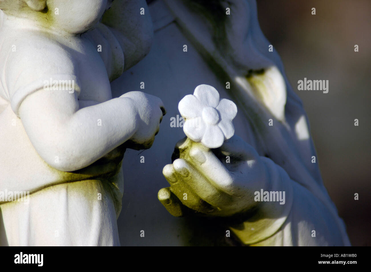 I marcatori di tomba nel cimitero in Sud America USA e la pulizia del sito con le statue di Maria e Gesù e fiori Foto Stock